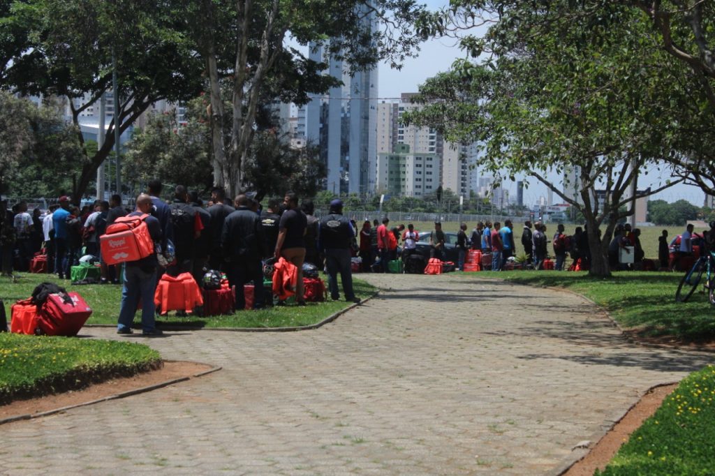 Motociclistas de aplicativo se reúnem em praça do Jd. Aquarius para troca de mochilas
