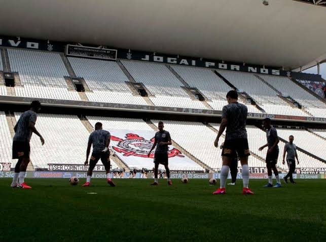 Pouco antes de reiniciar os treinos presenciais no Estádio Nilton Santos ontem (20), o Botafogo divulgou o resultado de 353 testes para identificar o novo coronavírus (covid-19 19)feitos semana passada por funcionários, jogadores e respectivos familiares. Ao todo 17 pessoas testaram positivo para covid-19: cinco atletas, seis familiares e seis membros da comissão técnica. De acordo com nota oficial, publicada no site do Alvinegro Carioca, os atletas já iniciaram o período de isolamento social e estão com acompanhamento diário do Departamento Médico. Os atletas que testaram positivo começaram a treinar de forma online. Outro clube que divulgou resultados dos testes de covid 19 ontem (20) foi o Corinthians. Em nota oficial, o Timão revelou que dos 190 testes realizados entre os dias 18 e 19 da semana passada, 13 deram positivo para covid-19. São oito atletas infectados - os nomes não foram divulgados - que estão assintomáticos. Eles ficarão afastados das atividades do CT por dez dias e serão submetidos a novos exames. Outras cinco pessoas da comissão técnica e de outros departamentos do CT também foram diagnosticadas com o vírus e seguirão o mesmo cronograma de avaliações dos atletas. Entre elas, o massagista Raimundo “Ceará”, o único que teve o nome divulgado na nota oficial do Corinthians. Ceará apresentou sintomas da doença, chegou a ser hospitalizado, mas vem se recuperando. Como o massagista faz parte do grupo de risco -acima dos 60 anos -, ele não retornará às atividades, assim como os demais funcionários do CT. O atacante Jô, recém-contratado, ainda não foi testado, o que deve ocorrer nos próximos dias. Amanhã (22) está prevista a reapresentação de 19 jogadores, apenas para retirarem Equipamentos de proteção Individual (EPI) e materiais de treino - uniformes e chuteiras devem ser higienizados pelos atletas em suas casas. As atividades físicas presenciais estão programadas para recomeçar na terça-feira (23).