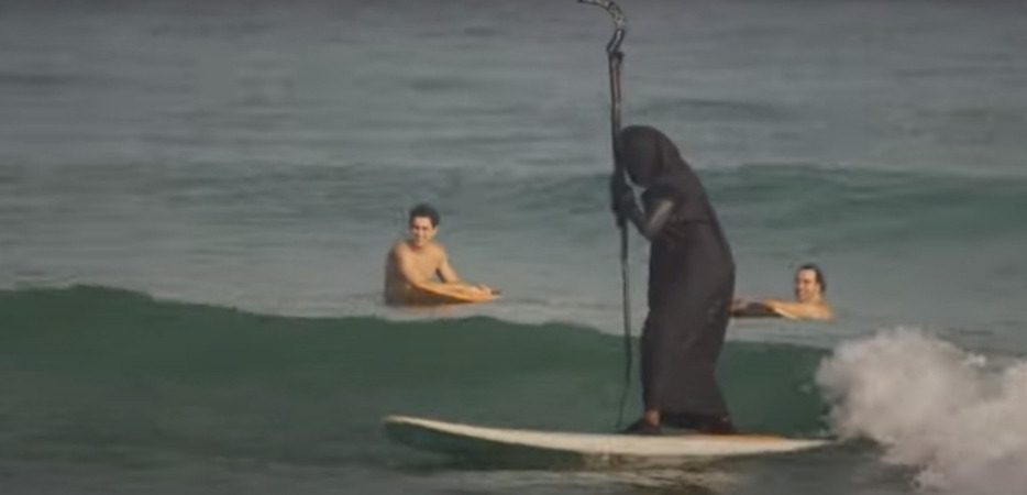 ‘Morte’ surfa em Praia de São Sebastião para alertar turistas