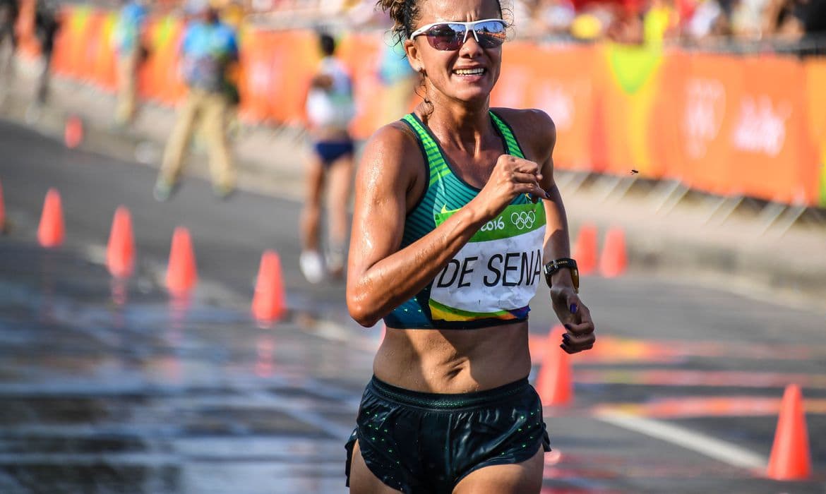 A pernambucana Érica Sena ficou bem perto de realizar o sonho de conquistar uma medalha inédita para o Brasil na marcha atlética na Olimpíada de Tóquio (Japão), na madrugada desta sexta-feira (6). Na reta final da prova de 20 quilômetros, a brasileira estava em terceiro lugar, o que lhe garantiria o bronze. Entretanto, cometeu uma infração e foi punida com a perda de dois minutos durante os quais teve de ficar parada, restando menos de um quilômetro para completar a prova. A atleta terminou a marcha na 11ª posição,em 1h31mim39s. A competição foi realizada no Parque Sapporo Odori, na cidade de Sapporo. Érica Sena, de 36 anos, foi punida por por causa de um movimento irregular, o que foi um golpe duro para a brasileira, que saiu da prova desolada e chorando bastante. Seria a primeira medalha na história da marcha atlética para o país. Quem conseguiu aproveitar o infortúnio da brasileira foi a chinesa Hong Liu (1h29mim12), que levou a medalha de bronze quando dificilmente conseguiria ultrapassar Erica, que estava próxima da medalhista de prata Sandra Lorena Arenas (1h29mim37s). O ouro acabou no peito da italiana Antonella Palmisano, com o tempo de 1h29min12. A atual sétima colocada no ranking mundial, a brasileira estreou em Olimpíadas na Rio 2016, quando terminou na sétima colocação. Esta seria a terceira conquista do atletismo brasileiro em Tóquio 2020. Os paulistas Alison dos Santos, o Piu, na prova de 400m com barreiras, e Thiago Braz, no salto com vara, levaram medalha de bronze.